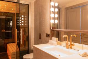 马德里Casa Faraona Luxury Residences的一间带水槽、镜子和卫生间的浴室