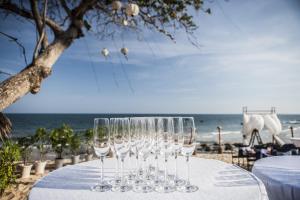 美奈阿罗马海滩Spa度假酒店的坐在海滩桌子上的一组酒杯