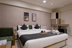艾哈迈达巴德Exora Inn的一间卧室配有一张大床和一张沙发