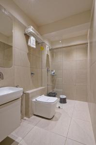 艾哈迈达巴德Exora Inn的浴室配有卫生间、盥洗盆和淋浴。
