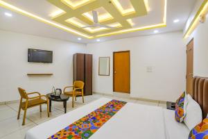 PhandaFabHotel Dhruva的配有一张床和一张桌子及椅子的房间