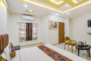PhandaFabHotel Dhruva的一间设有两张床、一张桌子和一把椅子的房间