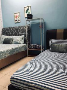 瓜拉弄宾E&Y HOMESTAY的一间卧室设有两张床和蓝色的墙壁