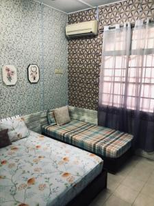 瓜拉弄宾E&Y HOMESTAY的一间卧室设有两张床和窗户。