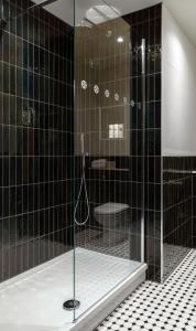 彻特西桥梁酒店的黑色瓷砖浴室设有淋浴和卫生间