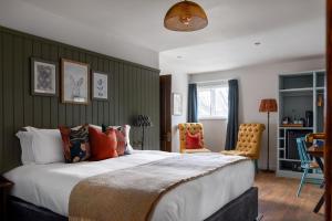 彻特西桥梁酒店的一间卧室配有一张大床和两把椅子