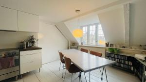 哥本哈根ApartmentInCopenhagen Apartment 1594的厨房配有白色的桌椅