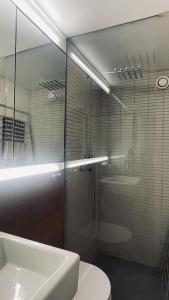 哥本哈根ApartmentInCopenhagen Apartment 1594的一间带玻璃淋浴和水槽的浴室