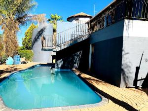 布隆方丹Eeufees Guesthouse的一座位于房子顶部的带阳台的游泳池