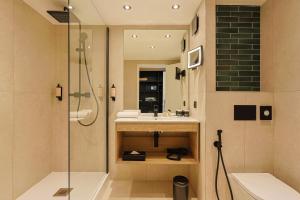 圣拉斐尔Golf Hôtel de Valescure & Spa NUXE的一间带水槽和淋浴的浴室