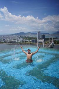 岘港GOLDEN APARTMENT With SEA VIEW的水中游泳池里的人
