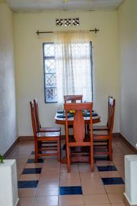 鲁亨盖里Rhoja homes的一间带桌子和四把椅子的用餐室