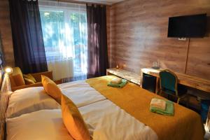 德丁基Hotel Raj的酒店客房设有一张大床和一张书桌。