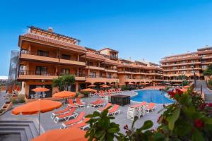 洛斯克里斯蒂亚诺斯Coral Los Alisios的一座设有游泳池、椅子和遮阳伞的酒店