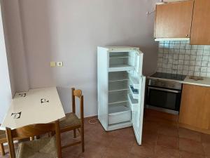 希俄斯Μεζονέτα Τοξότης的一间带开放式冰箱和桌子的小厨房