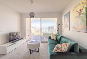 博索莱伊Superb New 2-room Apartment -parking Beausoleil的客厅配有绿色沙发和电视