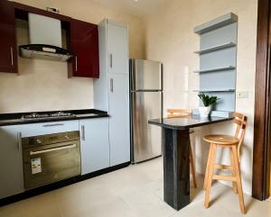安曼Luxury Abdoun apartment的厨房配有不锈钢冰箱和桌子