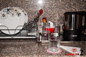 十月六日城Tulip 6 of October Hotel的厨房柜台配有咖啡机和玻璃杯