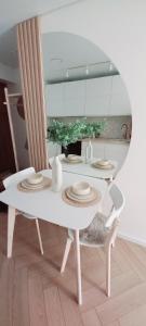 考纳斯Hygge Apartment in Silainiai, Kaunas的厨房里一张带盘子的白色桌子