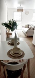 考纳斯Hygge Apartment in Silainiai, Kaunas的客厅,配有带盘子和花瓶的桌子