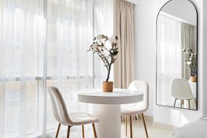 迪拜Silkhaus Modern Studio Near Silicon Central Mall的白色的用餐室配有白色的桌椅