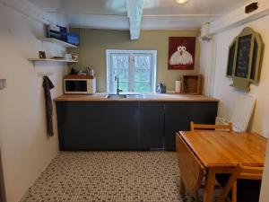 斯凯恩Ringkøbing Fjord B&B的厨房配有水槽、微波炉和桌子