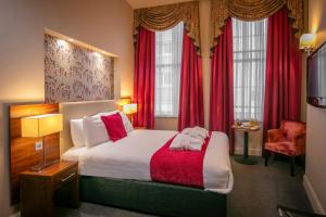 利物浦Heywood House Hotel, BW Signature Collection的酒店客房,配有床和红色窗帘