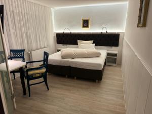 汉诺威哈泽酒店的卧室配有1张床、1张桌子和1把椅子