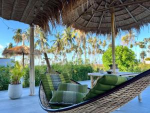 高兰Manao Seaview Pool Villa 20 - 5 Mins Walk To The Beach的天井上的吊床,配有遮阳伞和桌子