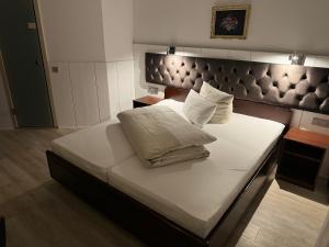 汉诺威哈泽酒店的一张配有白色床单和枕头的大床