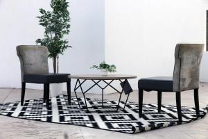 努瓦克肖特Garden Suites的地毯间配有两把椅子和一张桌子
