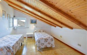 莫内利亚2 Bedroom Stunning Apartment In Moneglia的配有木天花板的客房内的两张床