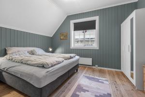 利勒哈默尔Central, large and light apartment in the middle of the city的一间卧室设有绿色的墙壁、一张床和窗户
