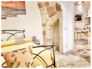 滨海波利尼亚诺Antica Pietra的一间卧室配有一张床和一个石头壁炉