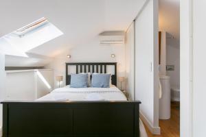 里斯本巴尔罗奥托阁楼公寓的一间卧室配有一张带蓝色枕头的大床