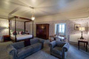 塔德卡斯特Hazlewood Castle & Spa的客厅配有床、沙发和椅子