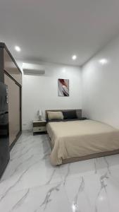 河内Homestay - Kim Mã - Giang Văn Minh的铺有大理石地板的白色客房设有一间带床铺的卧室