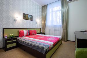 哈尔科夫Hotel Voyage的一间卧室配有一张带红色毯子的床和窗户。