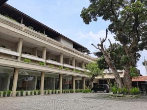 马格朗Hotel Catur Putra的前面有棵树的建筑