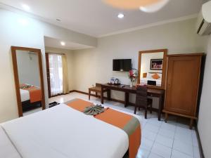 马格朗Hotel Catur Putra的配有一张床和一张书桌的酒店客房