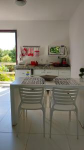 马塞约Villas do Pratagy Resort, Andar Superior的白色的厨房配有两把椅子和一张桌子