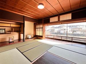高山Hostel Miyagawa by Murasaki Ryokan的一间设有大窗户和瑜伽垫的房间