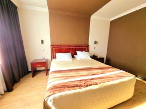 康塞普西翁埃尔阿拉乌卡诺酒店的一间卧室配有一张大床和红色床头板