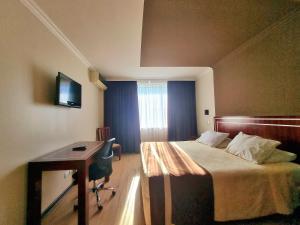 康塞普西翁埃尔阿拉乌卡诺酒店的酒店客房配有一张床和一张带电脑的书桌