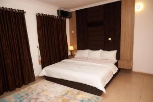 阿布贾1118 Serenity Residence的一间卧室配有一张带白色床单的大床