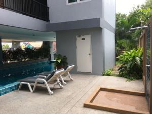 邦萨雷Condo Centerviews Bangsaray Beach的一个带椅子的庭院和一个游泳池