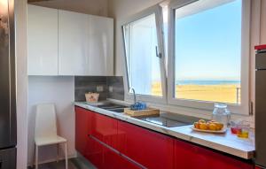 马洛塔piccolo chalet的一间厨房,配有红色橱柜和窗户
