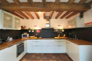 图尔184 Walvein - EGLISE的厨房配有白色橱柜和木制天花板