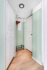 赫尔辛基Centrum - Lovely furnished Studio的空的走廊,有白色的门和木地板