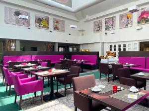 希莱斯海姆Augustiner Hotel的一间餐厅,房间内设有紫色椅子和桌子